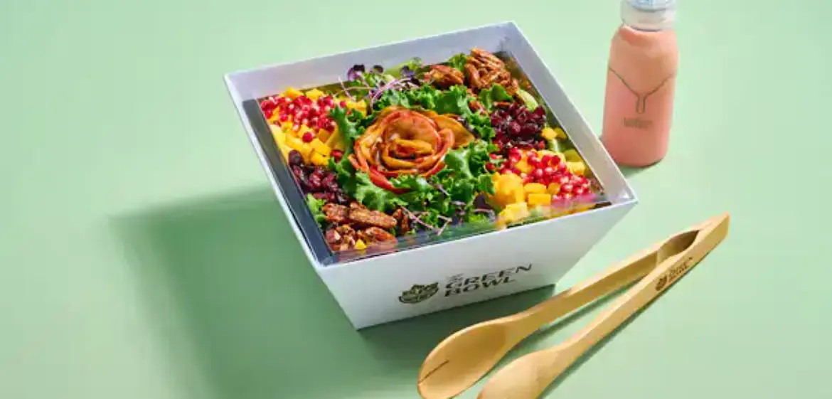 Green Bowl salad in a takeout box with tongs